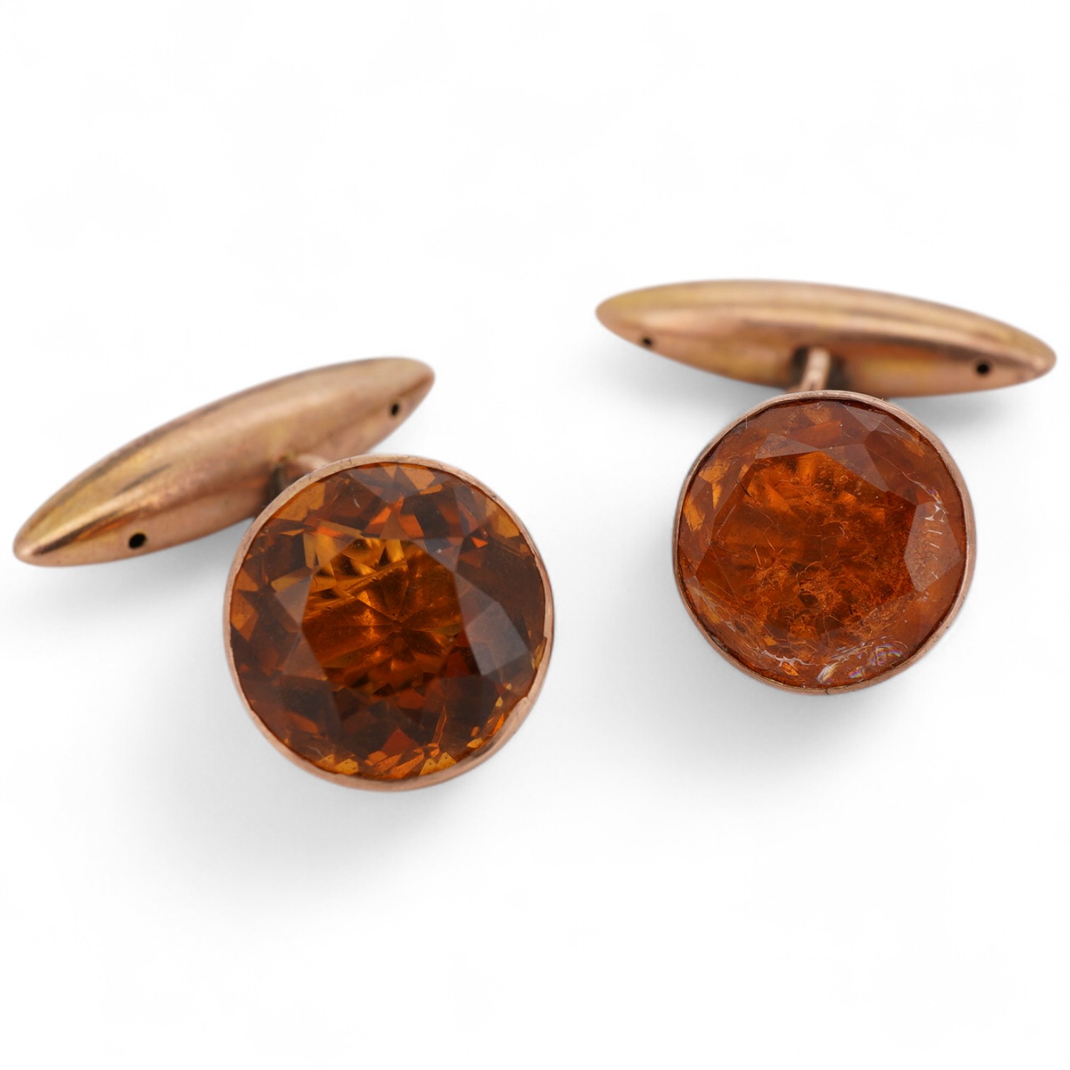 A pair of Edwardian cufflinks, early 20th century, one set with a circular-cut citrine, the other later set with a circular-cut doublet imitating citrine, mounted in gold, to torpedo-shaped back links, each mounted in go